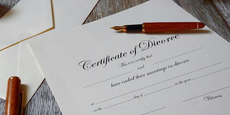 An ink pen lying on top of a divorce certificate