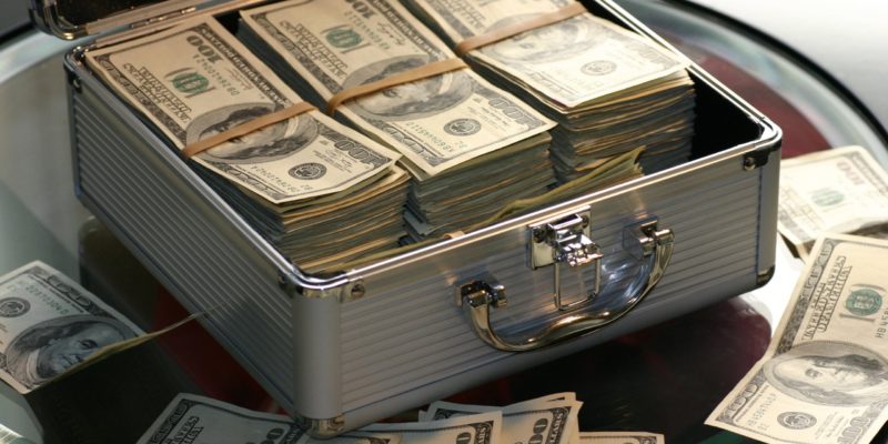 A small metal briefcase holding bundles of dollars