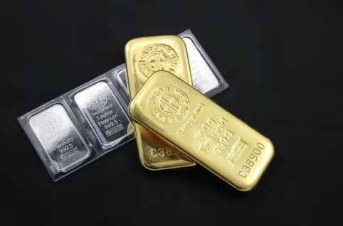 Gold and silver bars on a black surface