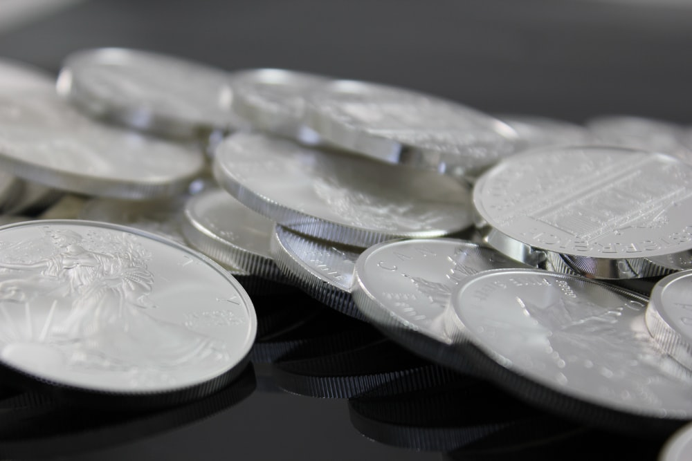 A close up of silver coins on a glass table