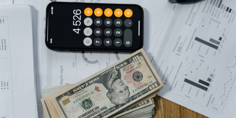 ten-dollar notes and a calculator on a desk