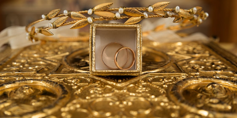 A gold tiara and rings placed on a table