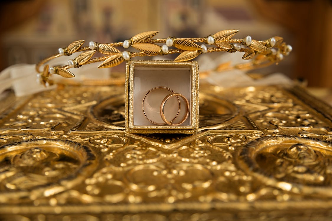 A gold tiara and rings placed on a table