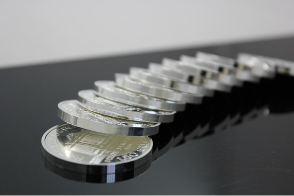 Platinum coins on a glossy surface.