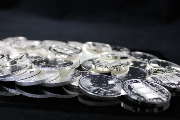A bunch of Silver coins placed on a glass table