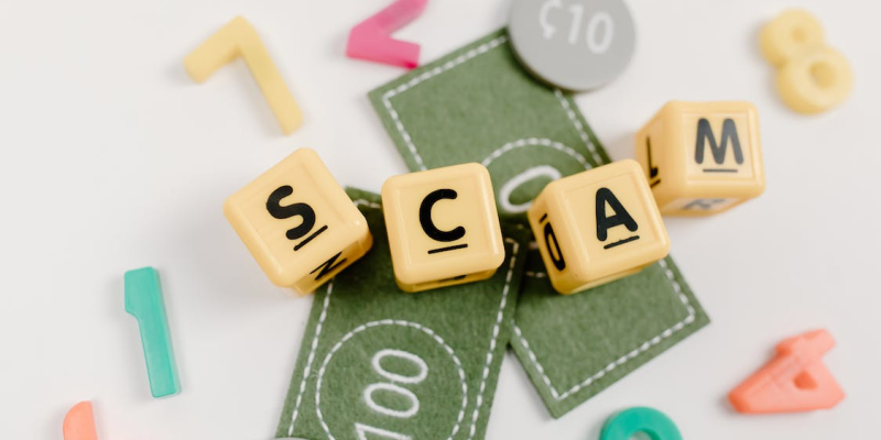 Scrabble tiles spelling out the word "scam"
