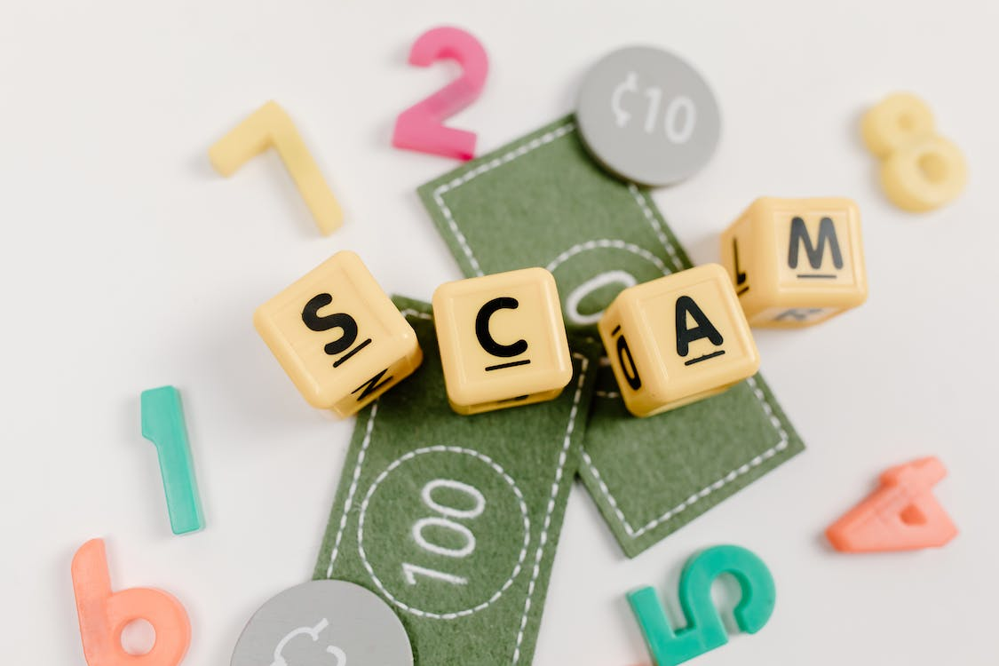 Scrabble tiles spelling out the word "scam"