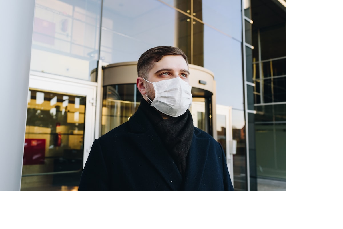 Person in black coat wearing a mask
