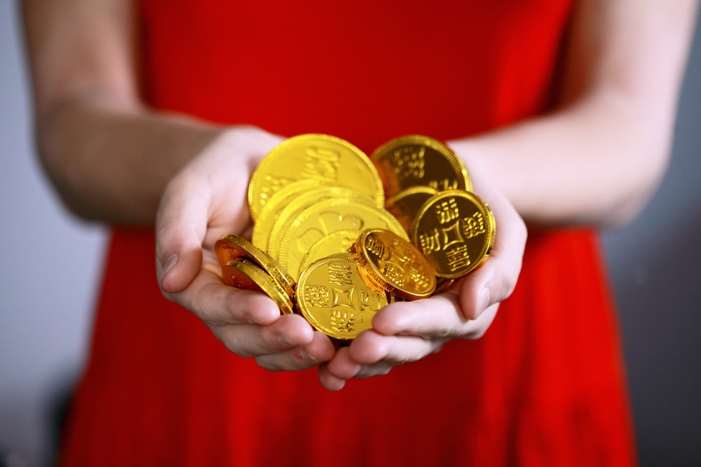 A woman holding gold coins