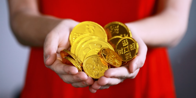 A woman holding gold coins