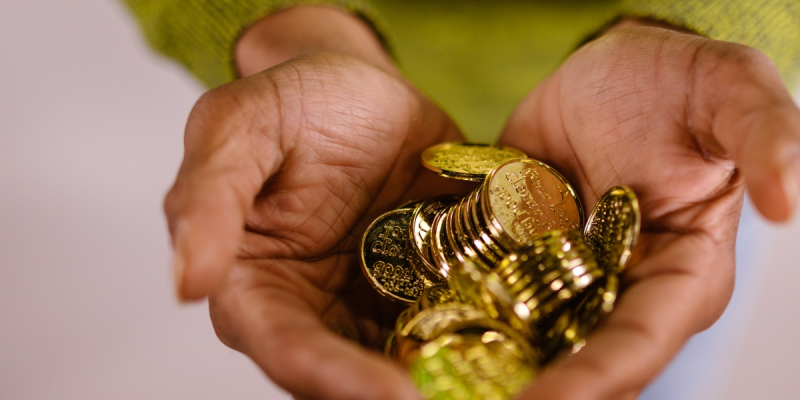 A person holding gold coins