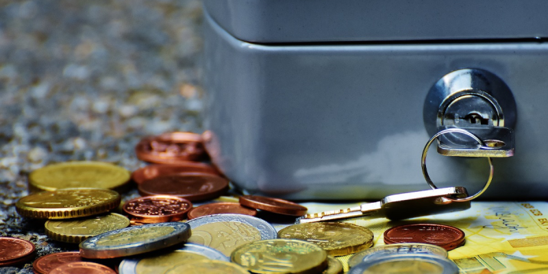 Bank Notes and Precious Metal Coins Beside a Safe Box