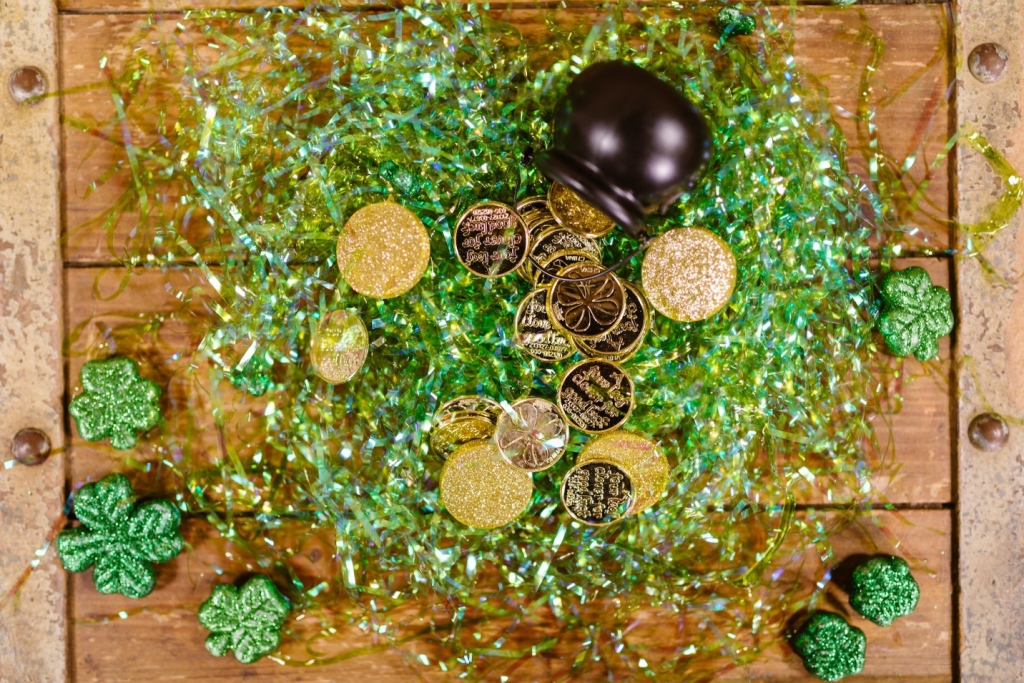 Gold Coins Scattered On Green Props On a Wooden Table