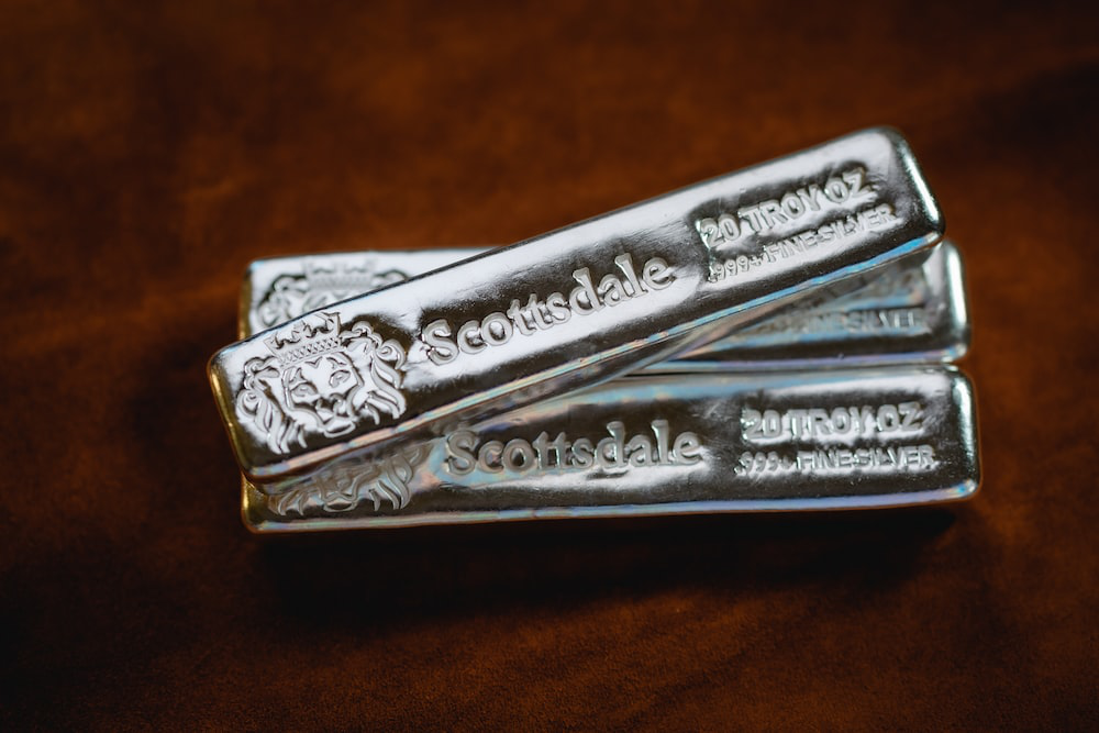 three silver bars are sitting on top of the table.