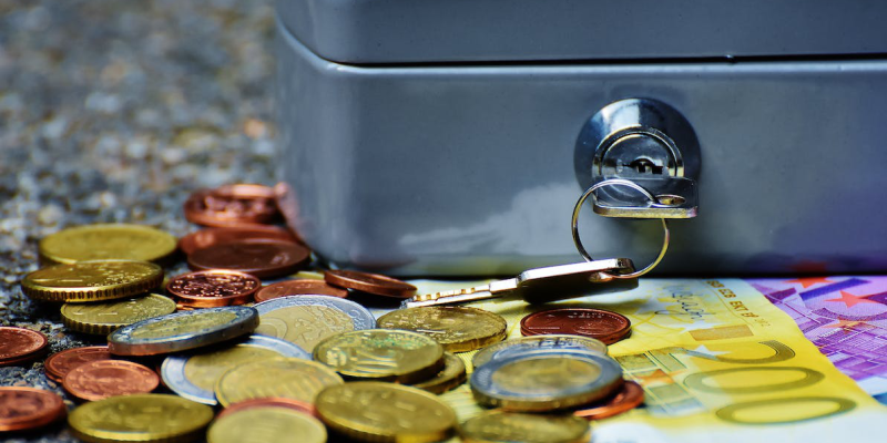 banknotes and coins beside gray safety box