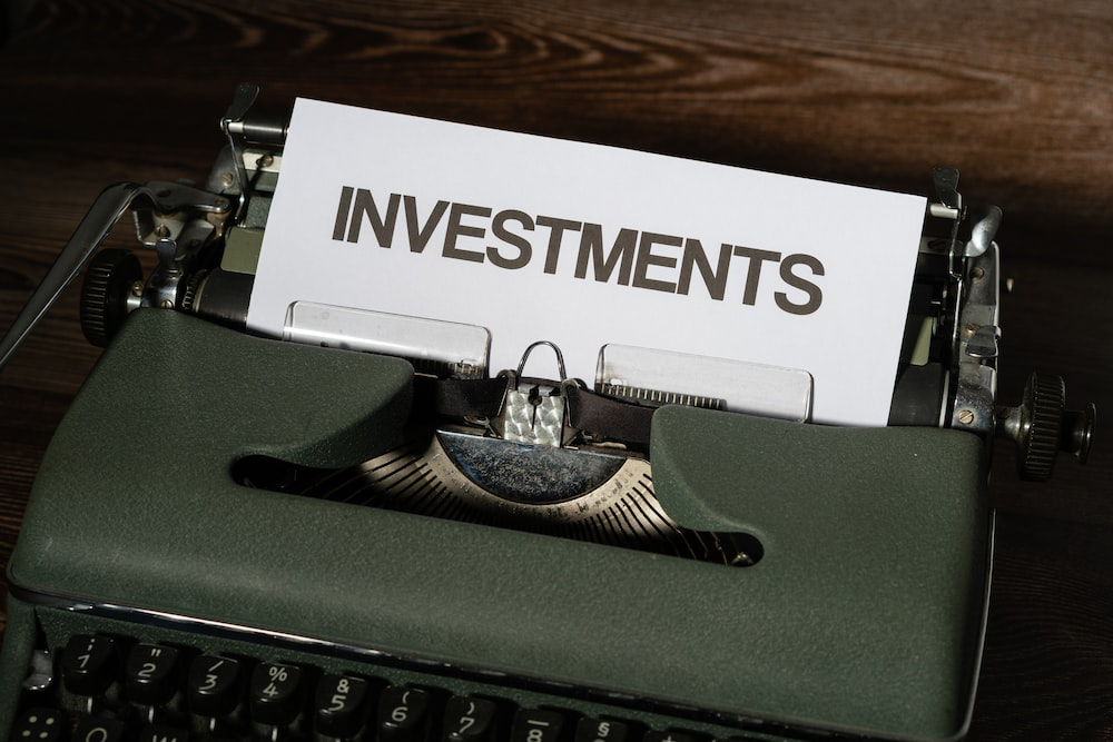 a paper saying investments on a typewriter.
