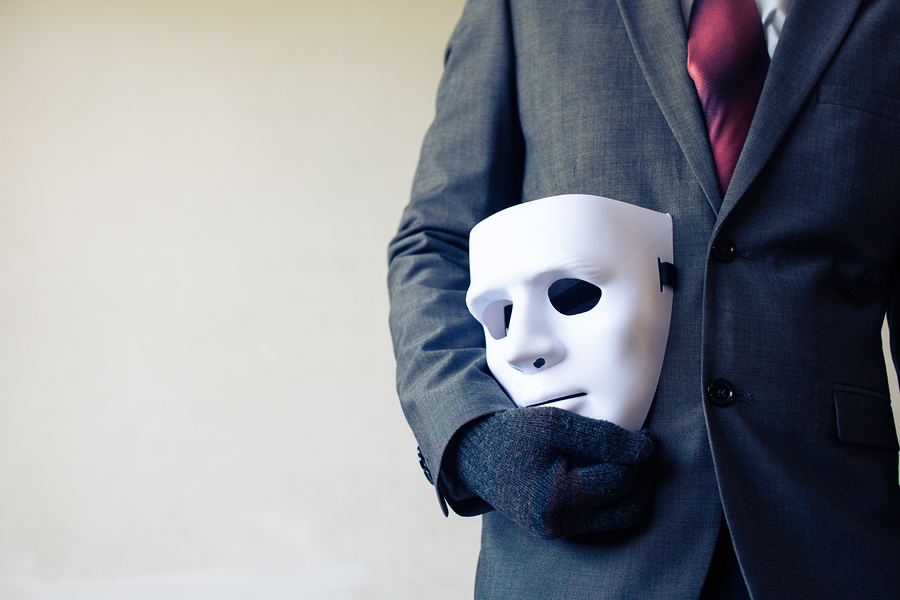Business man carrying white mask to his body indicating Business fraud and faking business partnership
