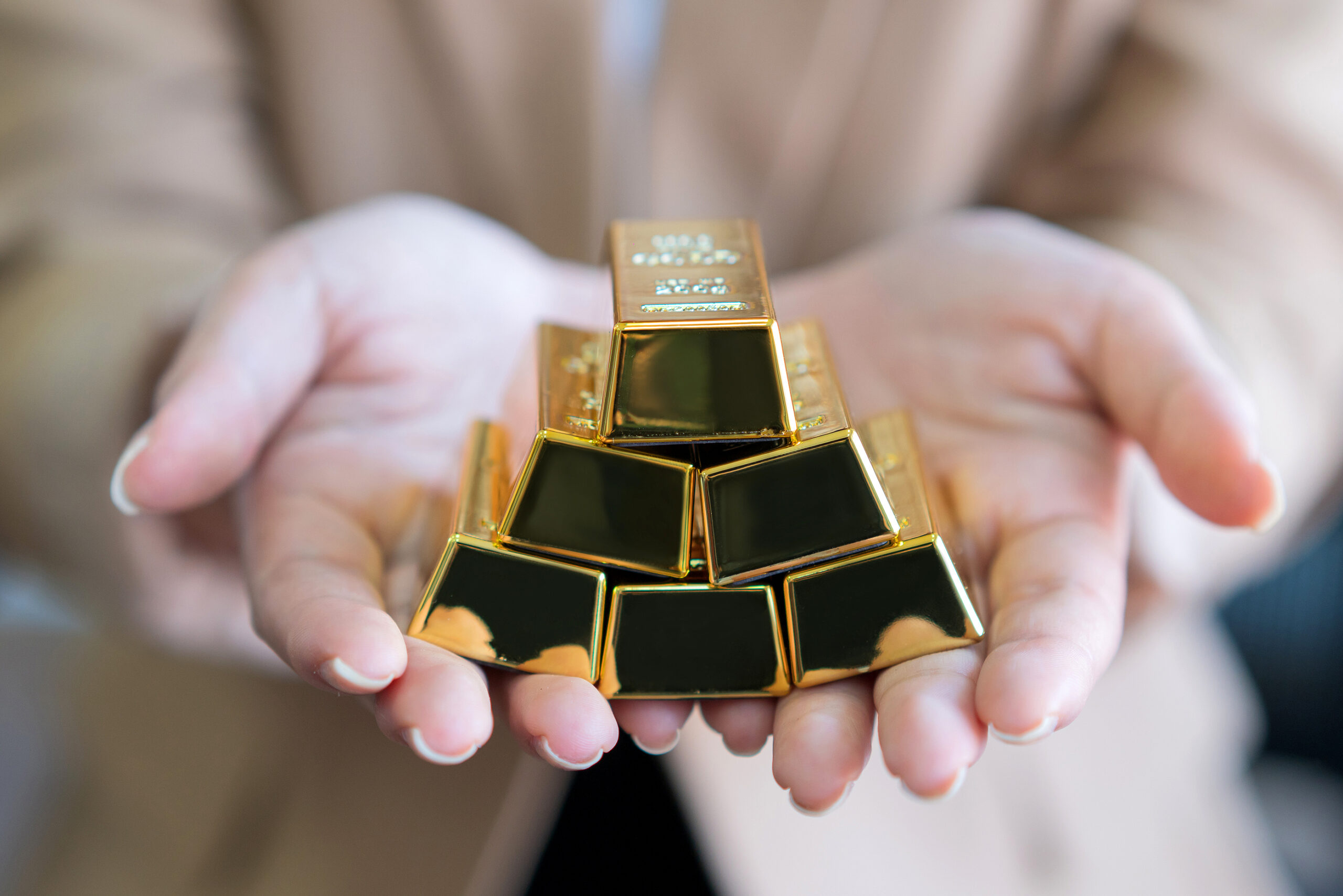 woman hands holding gold bars stack as secure investment.